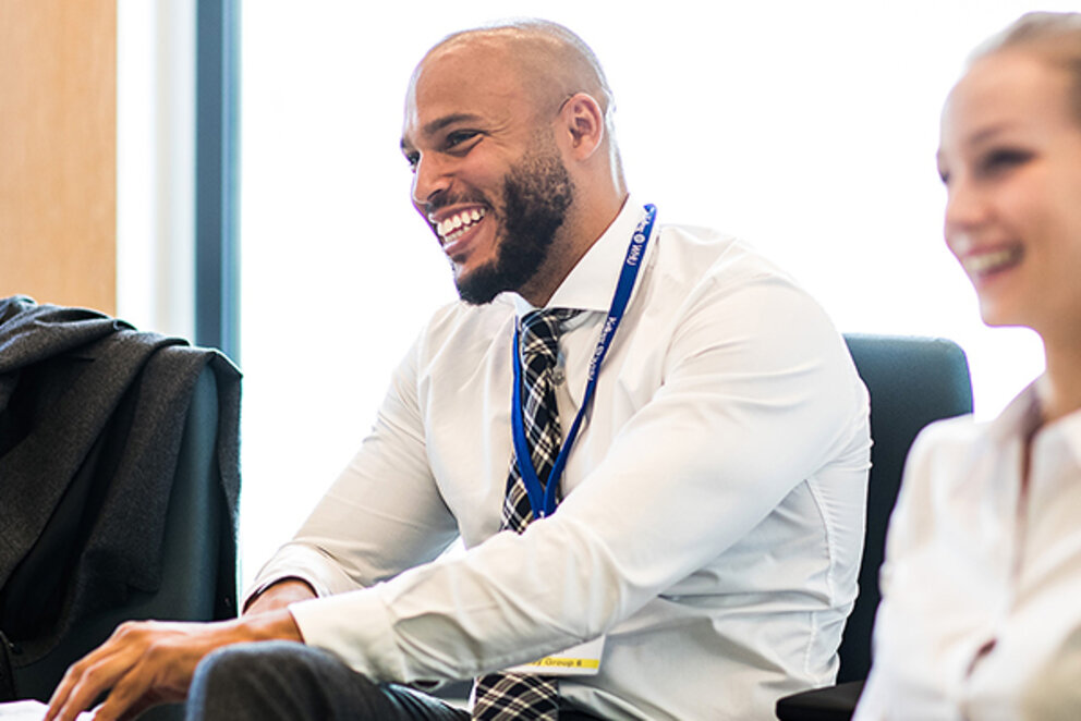 A laughing man sitting at a table with a woman