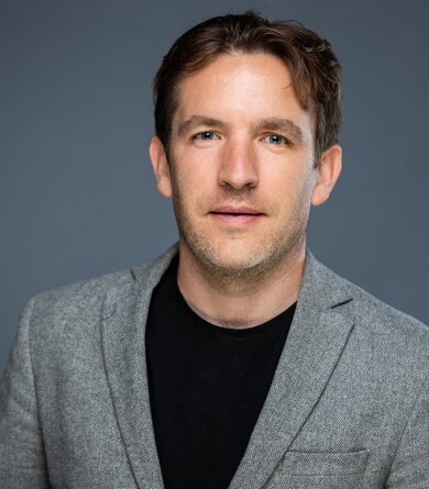 Portrait of a dark blond man in a grey jacket