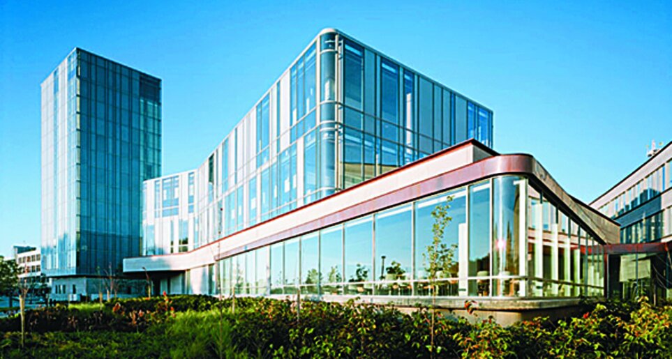 Zwei moderne Gebäude mit Glasfassaden, ein Turm und ein dreistöckiges Gebäude, auf dem Schulich Campus in Toronto