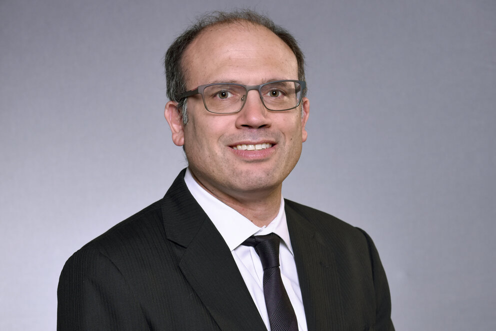 Employee photo of a man in a suit and glasses