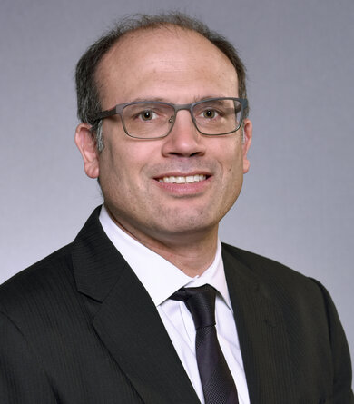 Employee photo of a man in a suit and glasses