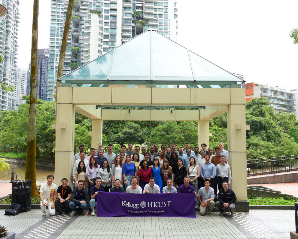 A group under a gazebo holding a banner that reads “Kellogg HKUST."